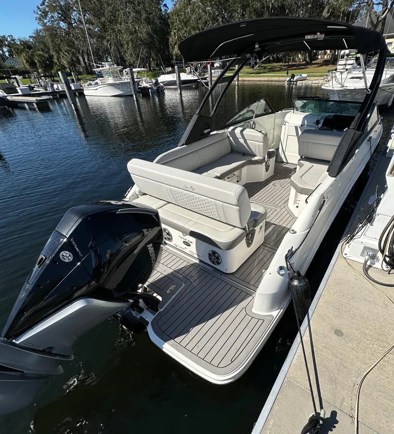 Slide: The Image of 2022 Sea Ray SDX 250 Outboard boat docked at marina, featuring spacious seating. - 6