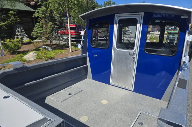 Slide: The Image of 2024 Spartan 240 Maximus boat with blue cabin and spacious deck. - 19