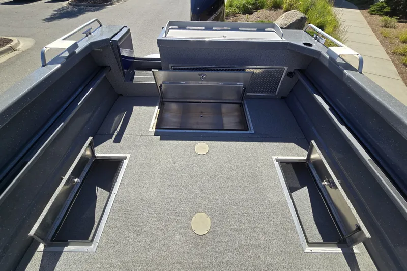 Slide: The Image of 2024 Spartan 240 Maximus boat interior with open storage compartments and sleek design. - 21