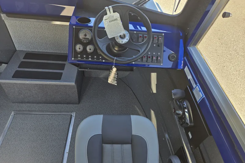 Slide: The Image of 2024 Spartan 240 Maximus boat cockpit with steering wheel and control panel. - 29