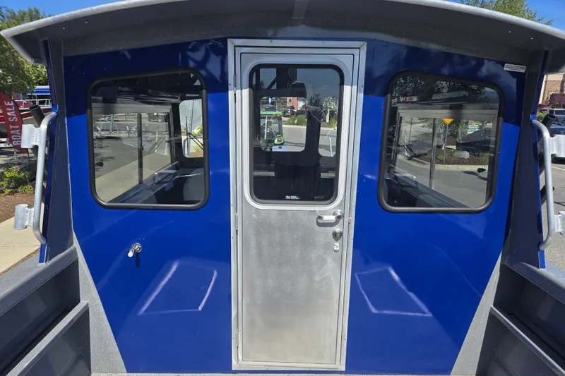 Slide: The Image of 2024 Spartan 240 Maximus boat with blue exterior and central door. - 26