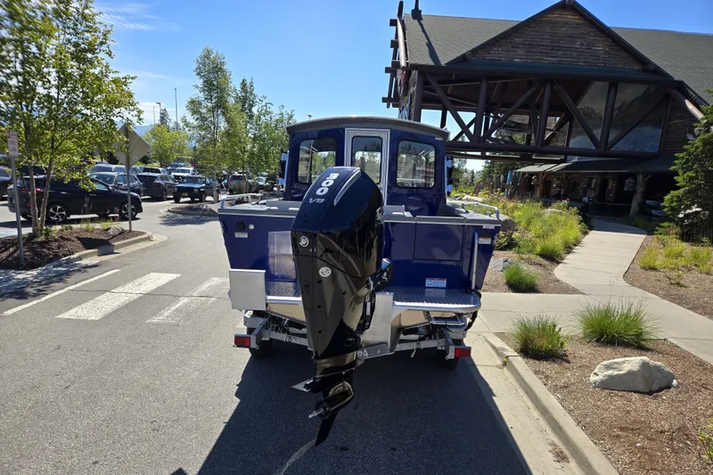 Slide: The Image of 2024 Spartan 240 Maximus boat with powerful outboard motor in a parking lot. - 16
