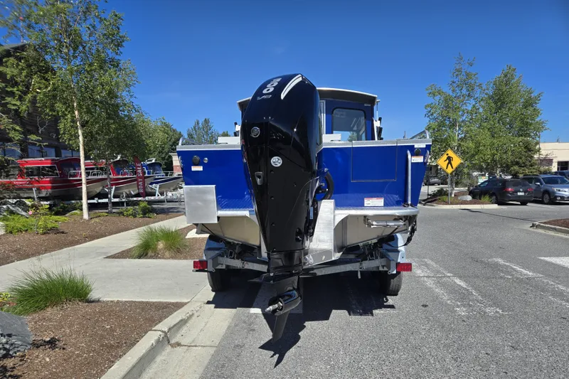 Slide: The Image of 2024 Spartan 240 Maximus boat on trailer, blue exterior, parked outdoors. - 13