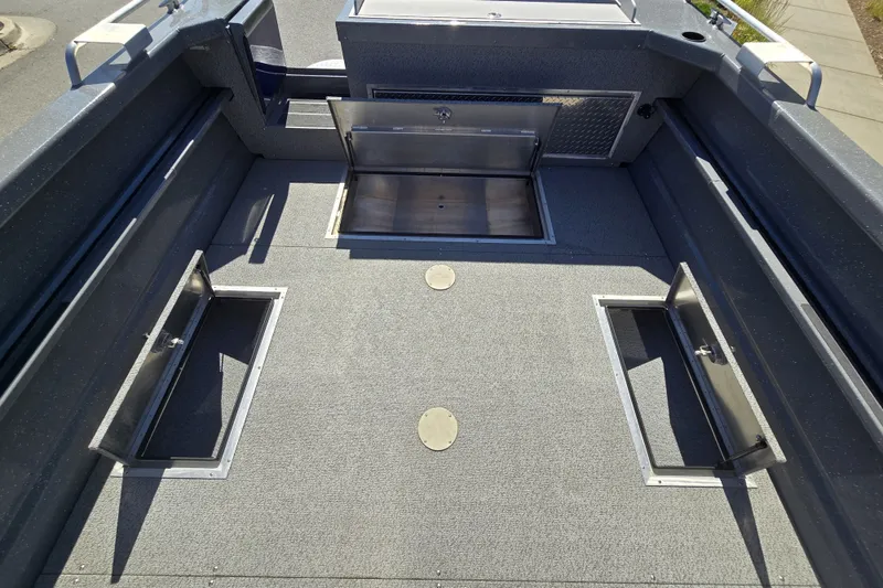 Slide: The Image of 2024 Spartan 240 Maximus boat interior with open storage compartments. - 22