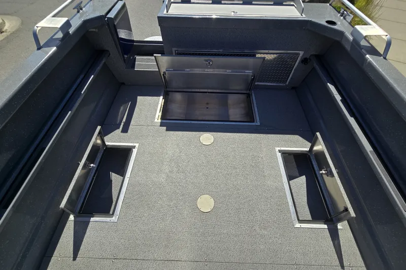 Slide: The Image of 2024 Spartan 240 Maximus boat interior with open storage compartments and sleek design. - 23