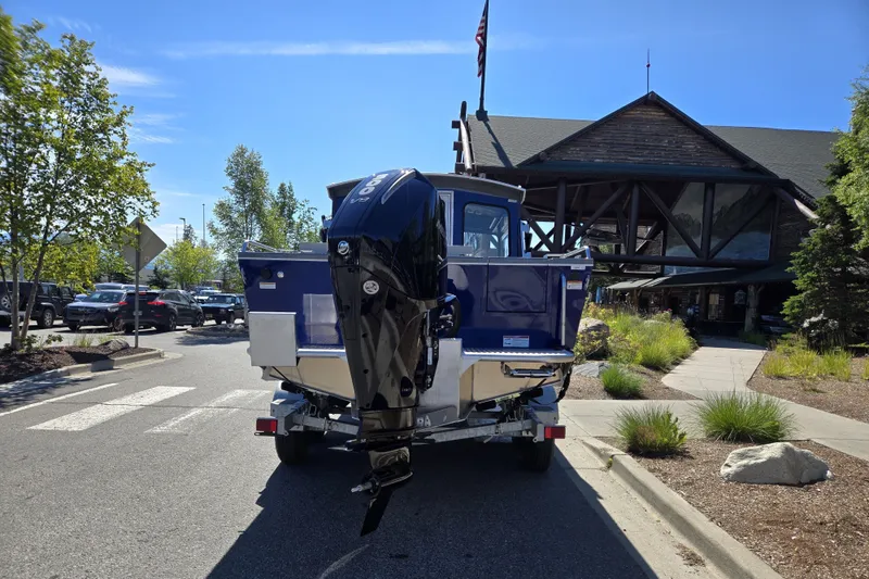 Slide: The Image of 2024 Spartan 240 Maximus boat on trailer outside rustic building. - 17