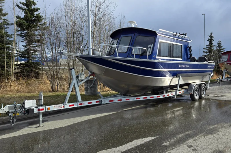 Slide: The Image of 2024 Spartan 26 Maximus Pro XL boat on trailer, parked outdoors. - 1