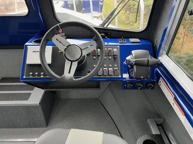Slide: The Image of 2024 Spartan 26 Maximus Pro XL boat cockpit with steering wheel and control panel. - 10