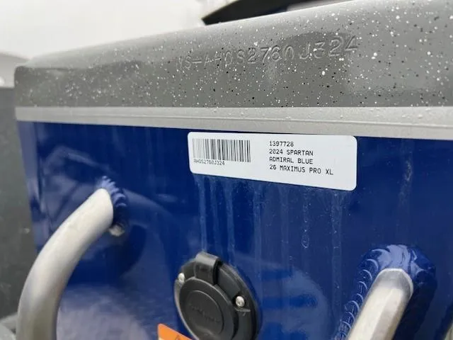 Slide: The Image of 2024 Spartan 26 Maximus Pro XL boat control panel with steering wheel and throttle levers. - 11