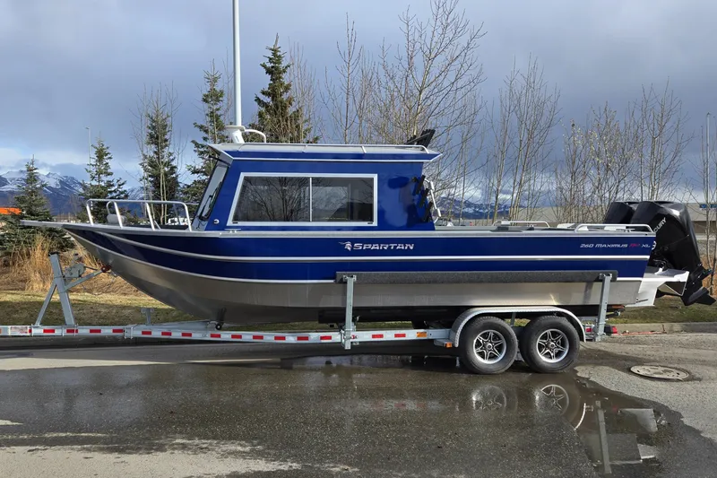 Slide: The Image of 2024 Spartan 26 Maximus Pro XL boat on trailer, parked outdoors. - 2
