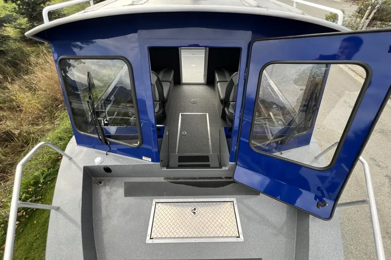 Slide: The Image of 2024 Spartan 26 Maximus Pro XL boat with open cabin doors and interior view. - 25