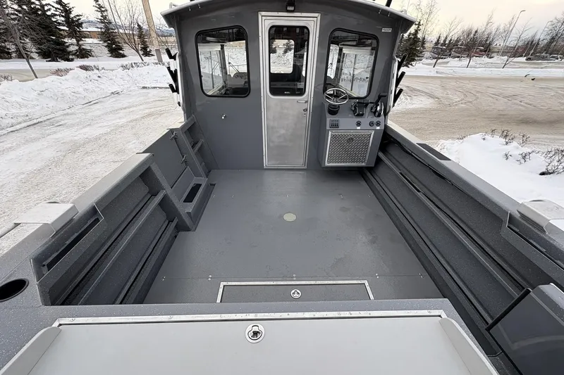 Slide: The Image of 2024 Spartan 26 Maximus Pro XL boat interior with spacious deck in snowy setting. - 15
