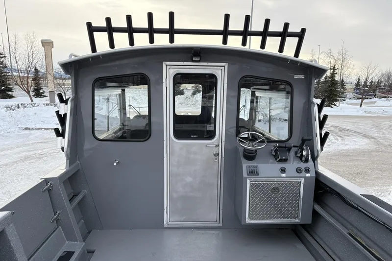 Slide: The Image of 2024 Spartan 26 Maximus Pro XL boat, gray exterior, snowy background, docked. - 16