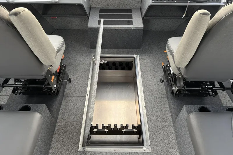 Slide: The Image of 2024 Spartan 26 Maximus Pro XL interior with open storage compartment between seats. - 23