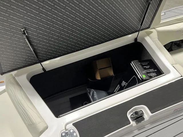 Slide: The Image of 2025 Nautique Super Air Nautique G25 storage compartment open, showing interior contents. - 10