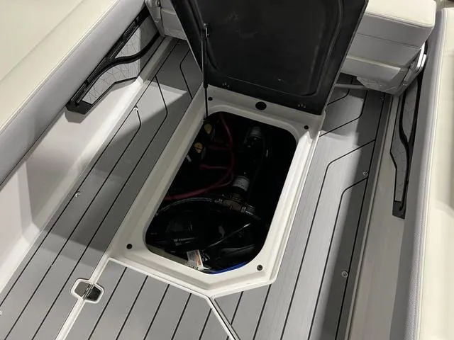 Slide: The Image of 2025 Nautique Super Air Nautique G25 storage compartment with open hatch, showcasing interior details. - 16