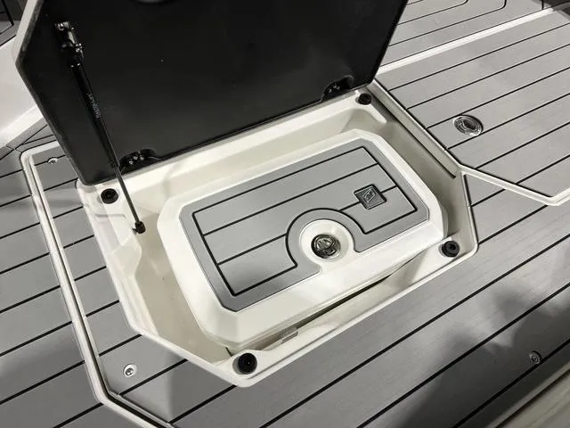 Slide: The Image of 2025 Nautique Super Air Nautique G25 storage compartment with open lid on deck. - 17