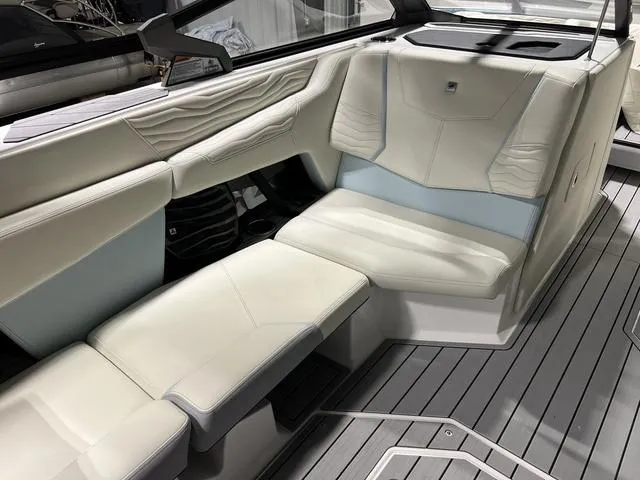 Slide: The Image of 2025 Nautique Super Air Nautique G25 interior with luxurious white seating and sleek design. - 19
