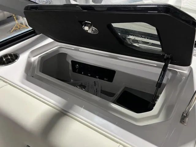 Slide: The Image of 2025 Nautique Super Air Nautique G25 storage compartment with open lid and interior view. - 24