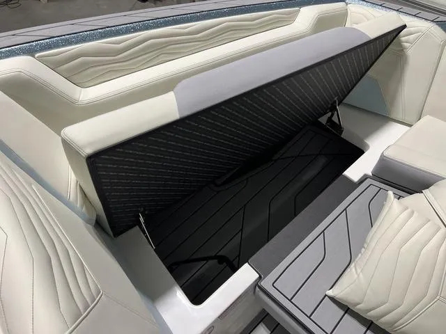 Slide: The Image of 2025 Nautique Super Air Nautique G25 interior seating with storage compartment open. - 31
