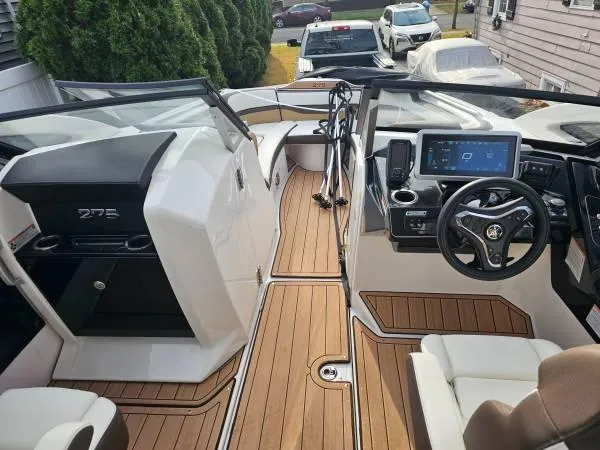 Slide: The Image of 2023 Yamaha Boats 275 SDX interior with modern dashboard and wood flooring. - 15
