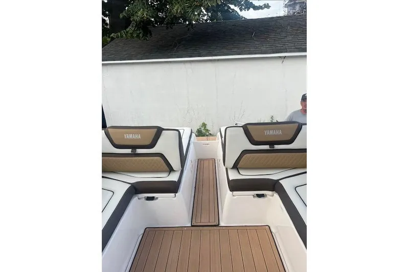 Slide: The Image of 2023 Yamaha Boats 275SDX interior with cushioned seating and teak-style flooring. - 16