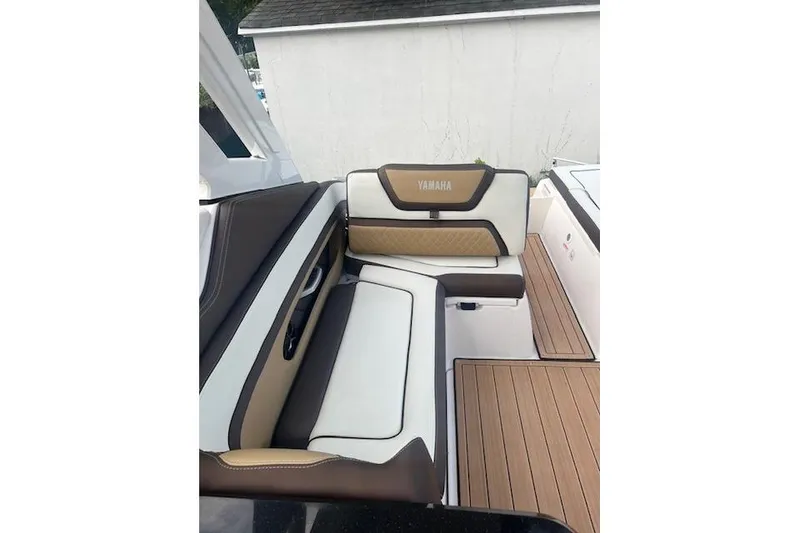 Slide: The Image of 2023 Yamaha Boats 275SDX interior seating with brown and white upholstery. - 17