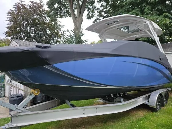 Slide: The Image of 2023 Yamaha Boats 275 SDX on trailer, sleek blue design, parked outdoors. - 2