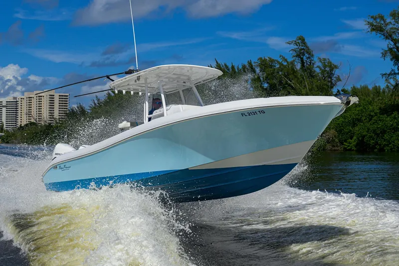 Slide: The Image of 2023 Powerplay Powerboats 30 RumRunner speeding on water, surrounded by lush greenery. - 1
