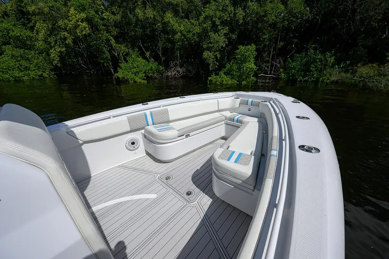 Slide: The Image of 2023 Powerplay Powerboats 30 RumRunner with sleek seating, docked by lush greenery. - 17
