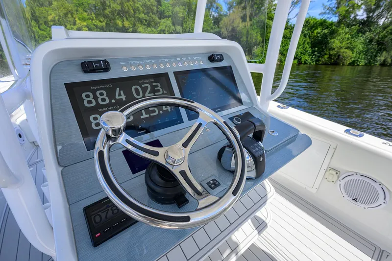 Slide: The Image of 2023 Powerplay Powerboats 30 RumRunner dashboard with steering wheel and digital displays. - 24