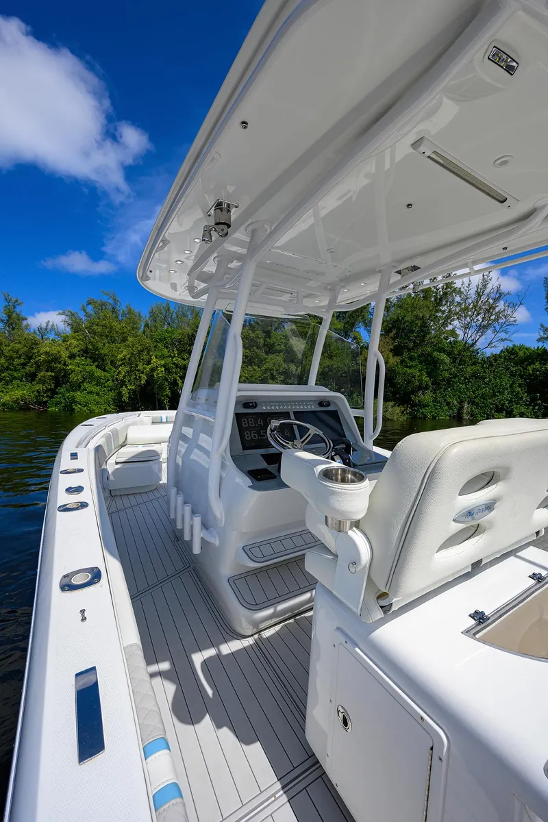 Slide: The Image of 2023 Powerplay Powerboats 30 RumRunner, sleek white interior, open water, clear blue sky. - 26