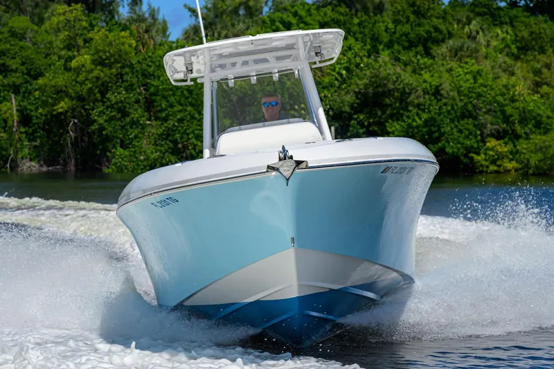Slide: The Image of 2023 Powerplay Powerboats 30 RumRunner speeding on water, surrounded by lush greenery. - 5