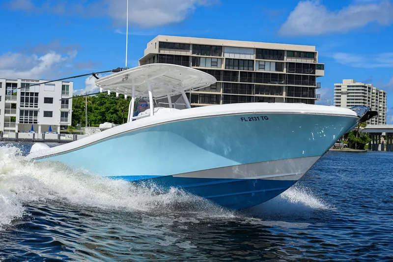 Slide: The Image of 2023 Powerplay Powerboats 30 RumRunner cruising on water near modern buildings. - 7