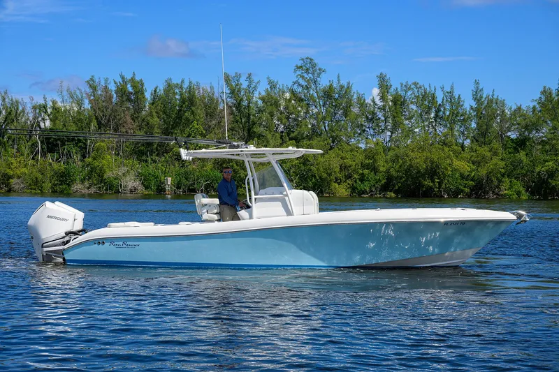 Slide: The Image of 2023 Powerplay Powerboats 30 RumRunner on a serene lake with lush greenery. - 9