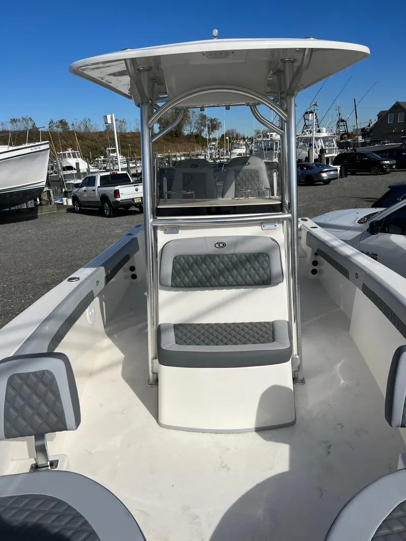 Slide: The Image of 2025 Defiance Catalina 240 boat with seating, T-top, and sleek design in a marina setting. - 20
