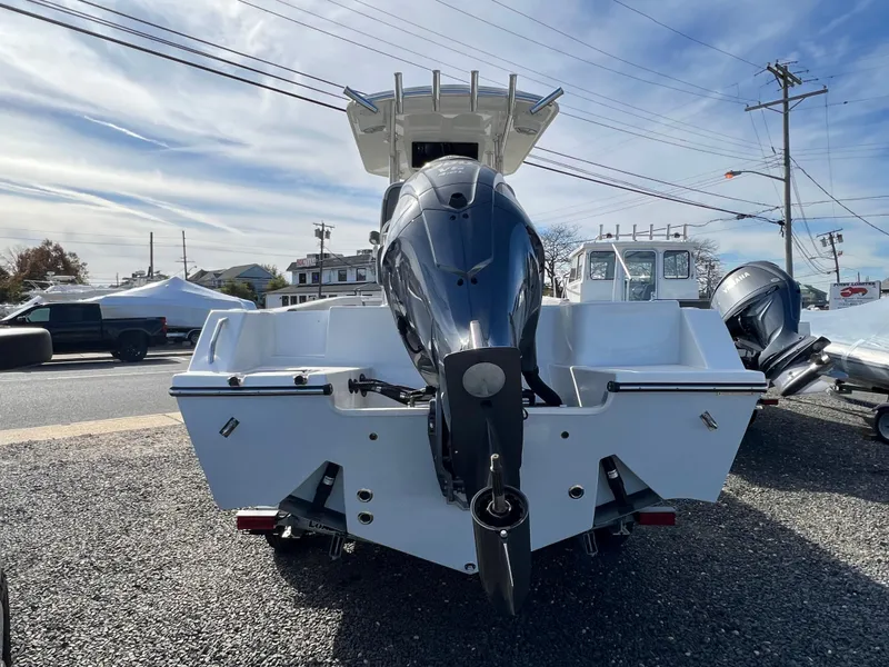 Slide: The Image of 2025 Defiance Catalina 240 boat with powerful outboard motor, parked on gravel lot. - 4