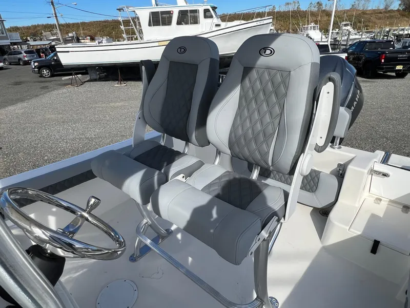 Slide: The Image of 2025 Defiance Catalina 240 boat interior with dual gray seats and steering wheel. - 15