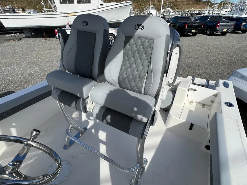 Slide: The Image of 2025 Defiance Catalina 240 boat seats with quilted design in a marina setting. - 22