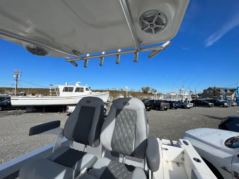 Slide: The Image of 2025 Defiance Catalina 240 boat seats under clear blue sky in marina. - 26