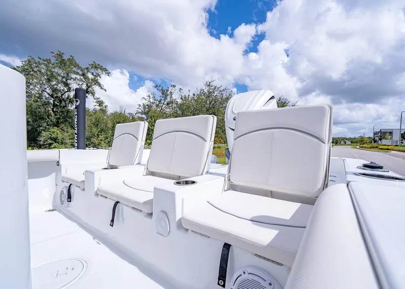 Slide: The Image of 2025 Sea Hunt BX 25 FS boat with white seating under a blue sky. - 16