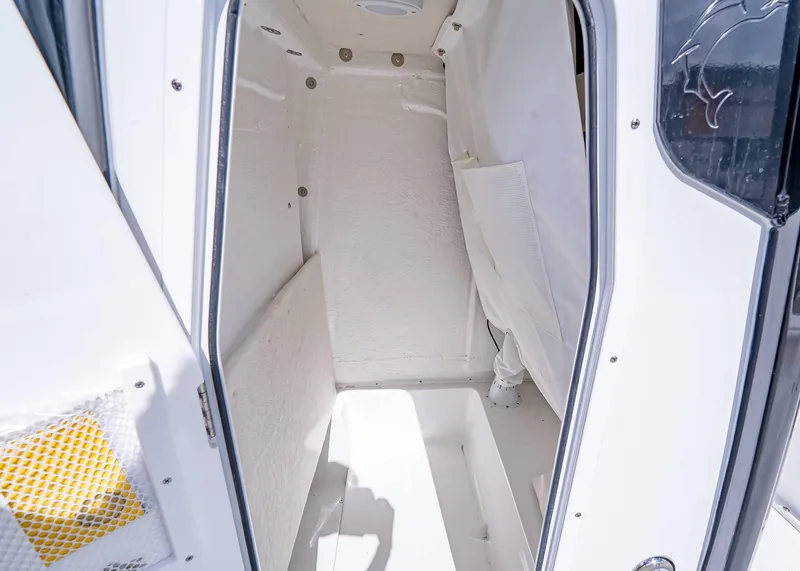 Slide: The Image of Interior cabin of 2025 Sea Hunt BX 25 FS boat, featuring white walls and compact space. - 17