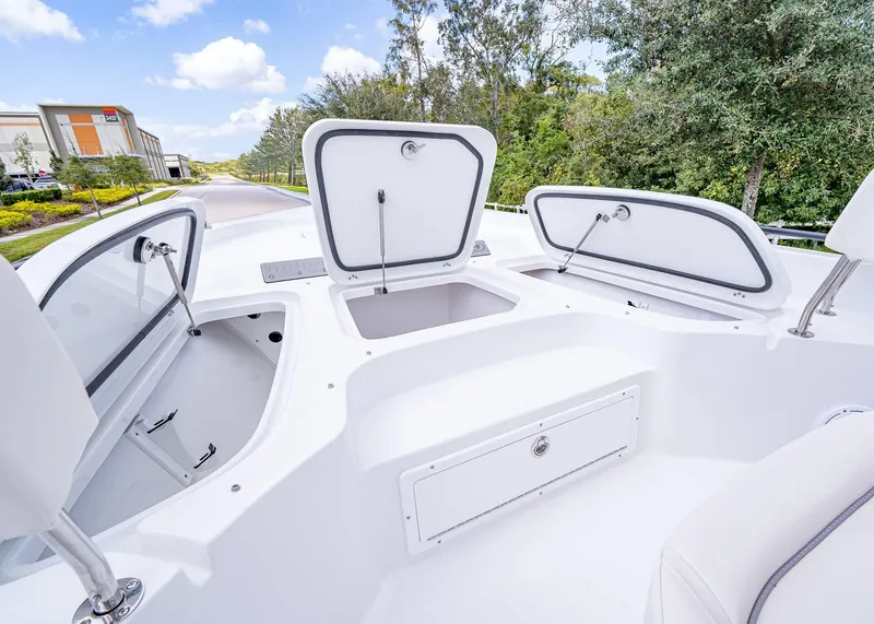 Slide: The Image of 2025 Sea Hunt BX 25 FS boat with open storage compartments, white interior, and outdoor setting. - 20