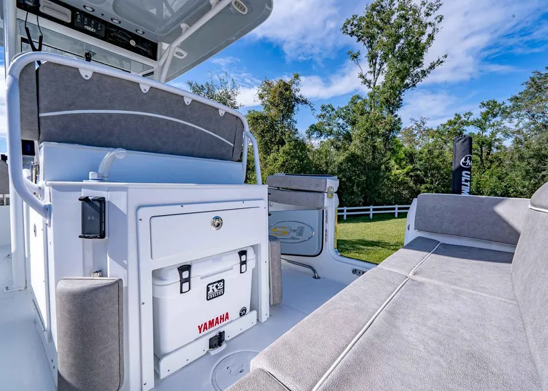 Slide: The Image of 2025 Sea Hunt Ultra 255 SE boat interior with seating and storage, surrounded by greenery. - 16