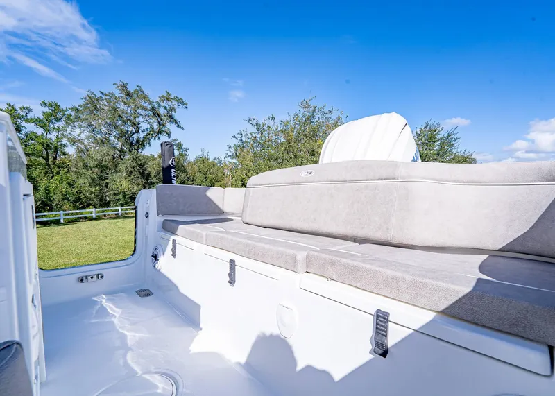 Slide: The Image of 2025 Sea Hunt Ultra 255 SE boat interior with cushioned seating under clear blue sky. - 17