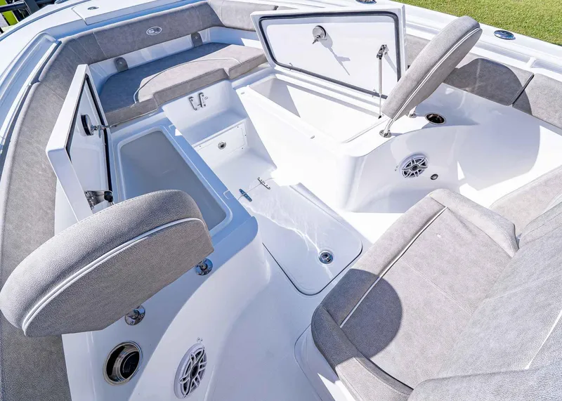 Slide: The Image of 2025 Sea Hunt Ultra 255 SE boat interior with open storage compartments and cushioned seating. - 21