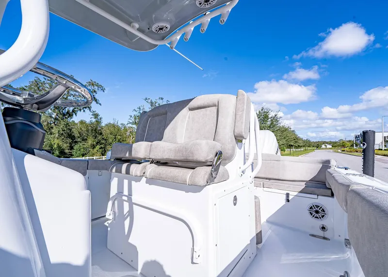 Slide: The Image of 2025 Sea Hunt Ultra 255 SE boat interior with seating and steering wheel under clear blue sky. - 22