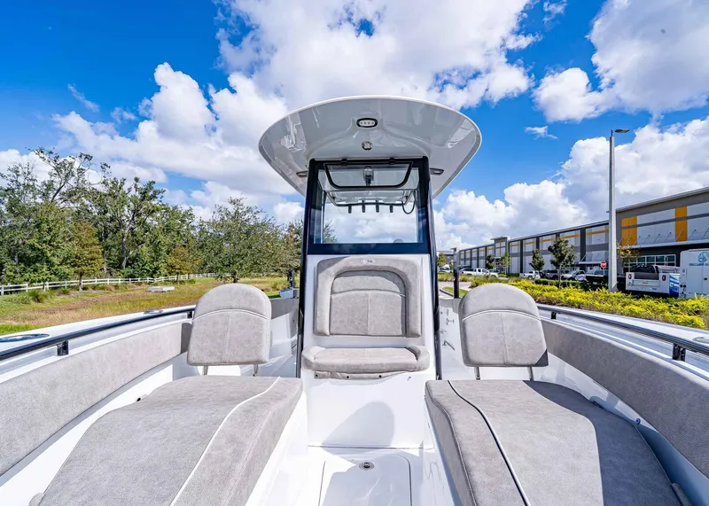 Slide: The Image of 2025 Sea Hunt Ultra 255 SE boat interior with plush seating under a blue sky. - 19