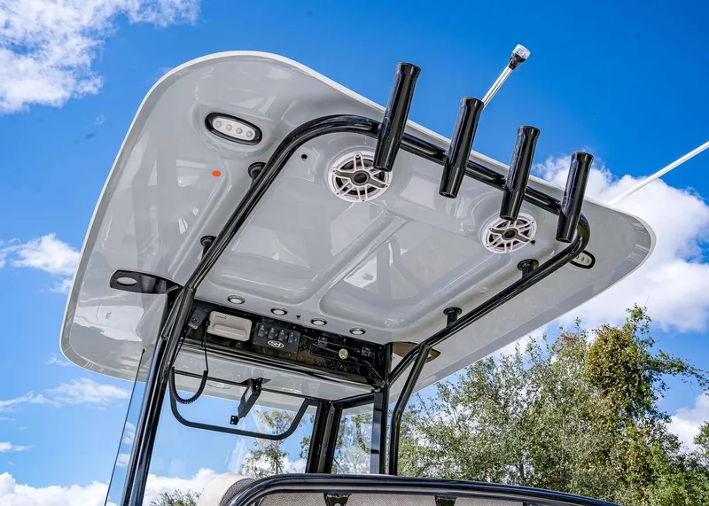 Slide: The Image of 2025 Sea Hunt Ultra 255 SE boat top with rod holders against blue sky. - 7