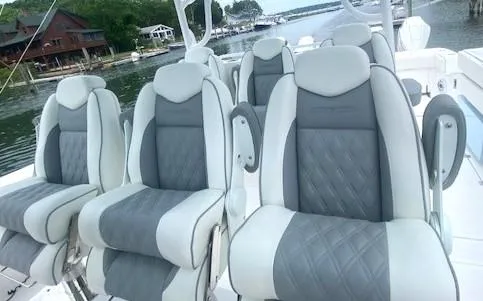 Slide: The Image of 2023 Invincible 46 Catamaran Plus Quad Axle Trailer with luxurious seating on a scenic waterfront. - 11